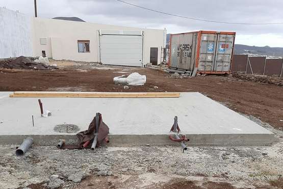Vista general de una plataforma de hormigón. Al fondo, un habitáculo con una puerta de garaje/TA.